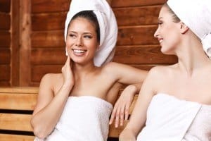 Two women chatting in a sauna.