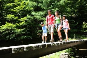 Group of people walking across bridge in the mountains