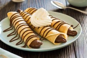 Three tasty crepes with chocolate filling.