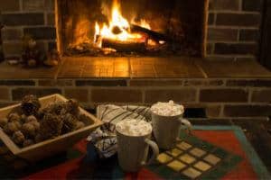 Two cups of hot cocoa by the fireplace