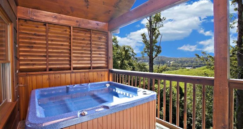 Hot tub outside cabin with mountain view