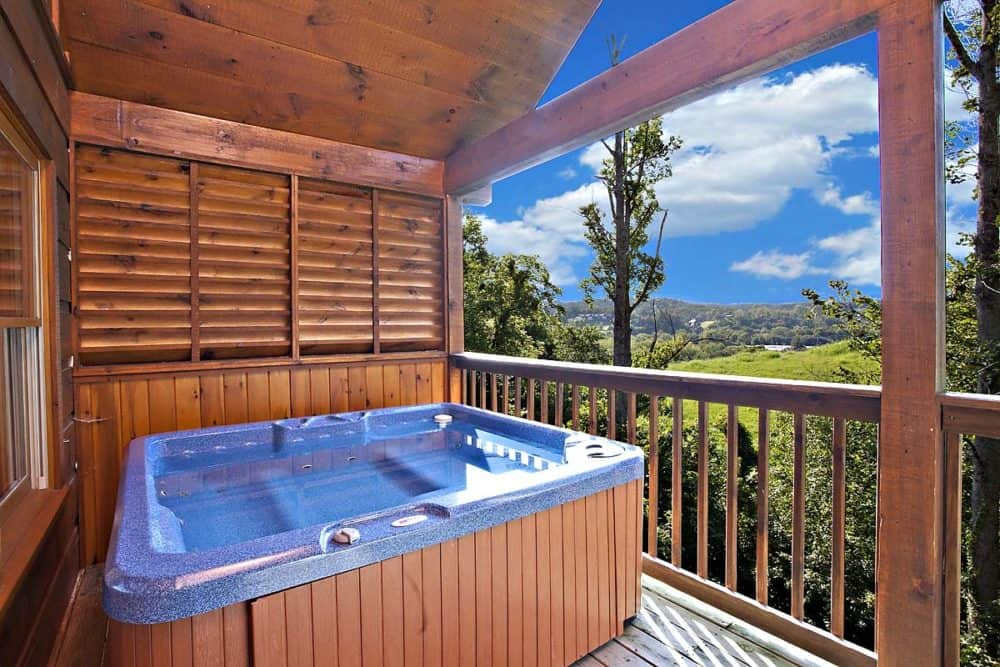 Hot tub outside cabin with mountain view